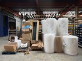 de nombreux rouleaux de papier blanc posés par terre dans un entrepôt