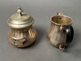 two silver pots sitting next to each other on a table