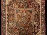 un tapis persan ancien présentant un motif géométrique sur fond noir