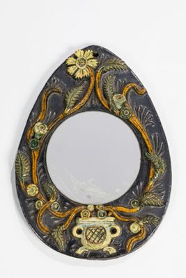 a mirror with a design on it hanging on a wall