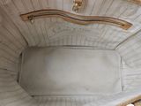 the inside of a white purse with a gold handle