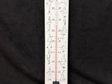 a white thermometer on a black background with a black background