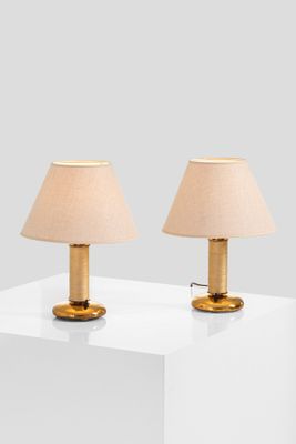 pair of brass table lamps with linen shades on a white table