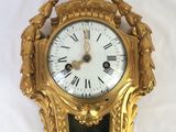 a gold clock that is hanging on the wall