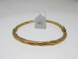 a close up of a gold plated wire bracelet with a price tag