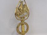 a gold bird on top of a brass object