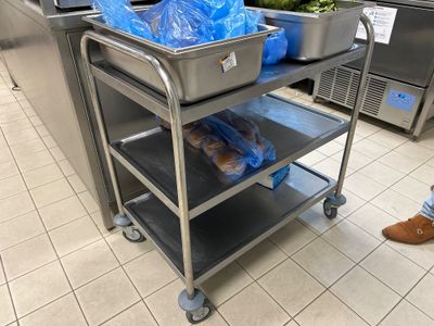 un chariot en métal sur lequel se trouvent deux plateaux de nourriture