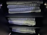 Les serviettes sont empilées sur une étagère dans une salle de bains, à côté d'un miroir