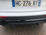 the rear end of a white car with a license plate on it