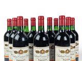 six bottles of red wine lined up in a row on a white surface