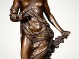 an antique bronze statue of a woman holding a flower