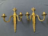 three antique brass wall sconces on a blue background