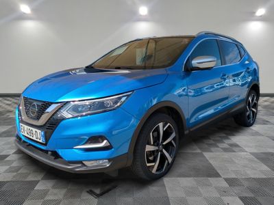 un SUV Nissan bleu garé dans une pièce au sol à carreaux