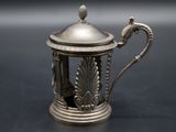 an antique silver teapot with a handle on a black surface