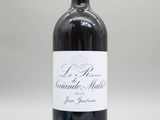 la bouteille de vin rouge est posée sur une surface blanche