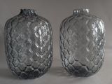 two clear glass vases sitting on a white surface