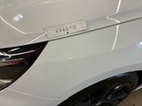 a close up of a white car with a sticker on it