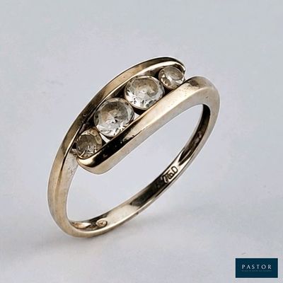 gros plan d'une bague en or ornée de trois diamants