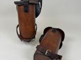 pair of brown leather cases with straps on them on a white background