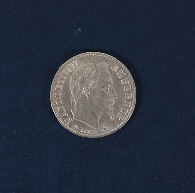 a silver coin on a blue surface with a black background