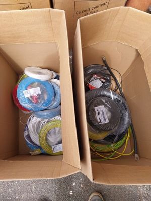 deux boîtes posées par terre, remplies de fils