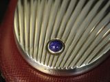 a red purse with a blue stone inside of it