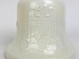 a white bell with an eagle on it on a white surface