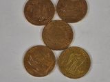 four different coins sitting on top of each other on a white surface
