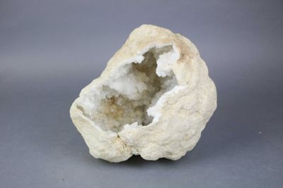 a white rock with a hole in it on a gray surface