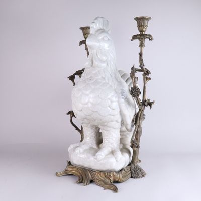 une image représentant une statue de coq perchée sur une branche d'arbre