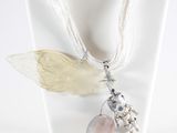 a necklace that has a butterfly on it and a flower on it