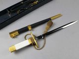 a black and gold knife and a black and gold pen on a table