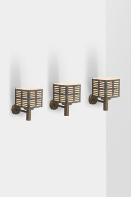 three sconces mounted on the wall of a bathroom with white walls
