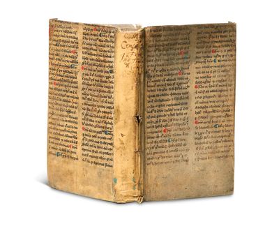 an old book with writing on it sitting on top of a white surface