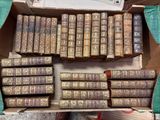 de nombreux vieux livres dans une boîte en carton posée par terre