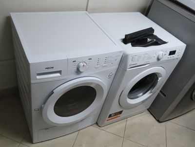 deux lave-linge et un sèche-linge placés côte à côte