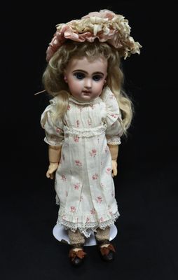 a doll that is wearing a white dress and hat