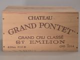une boîte en bois sur laquelle est apposée une étiquette portant l'inscription « Château Grand Pontnet »