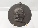 une photo d'une plaque représentant un homme aux cheveux longs