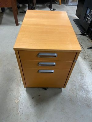 a wooden desk with three drawers on it in a room