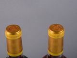 two bottles of wine sitting next to each other on a table