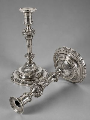 une paire de bougeoirs en argent sur fond gris
