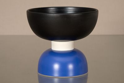 un bol noir posé sur un vase bleu