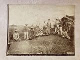 photograph of a group of men posing for a picture with a machine gun
