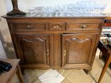 a wooden cabinet with a marble top and a lamp on top of it