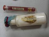 a bottle with a label on it next to a tube of toothpaste and a tube of toothpaste