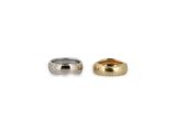 two gold and silver rings sitting side by side on a white background