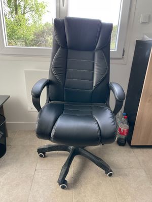 une chaise de bureau noire placée devant une fenêtre