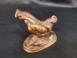 une statue en bronze représentant un oiseau sur un fond noir