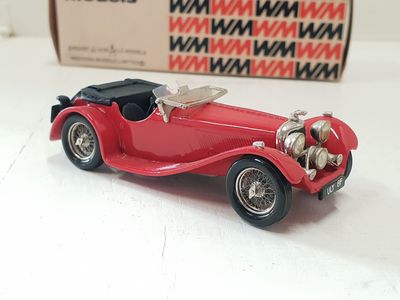 a red toy car sitting on a table next to a box
